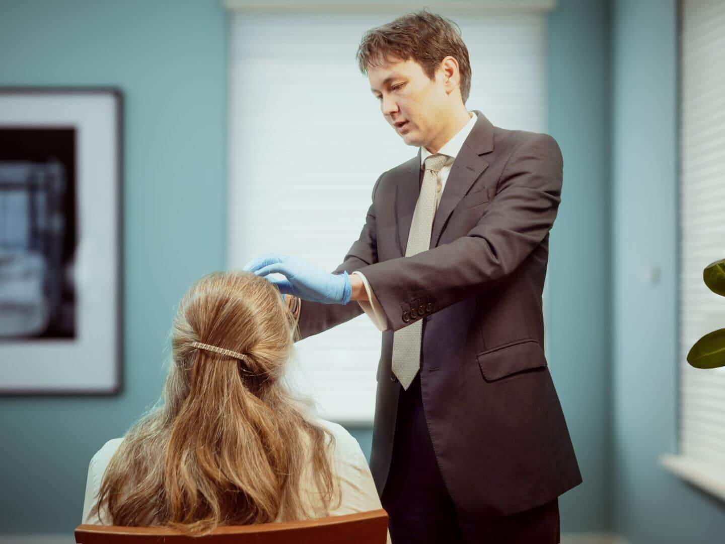 Surgeon Akira Wiberg examining female temporal migraine patient